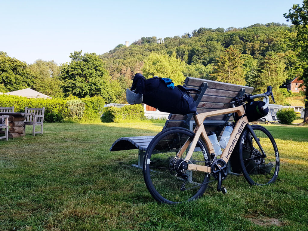 The wooden bicycle against a bench at the campsite