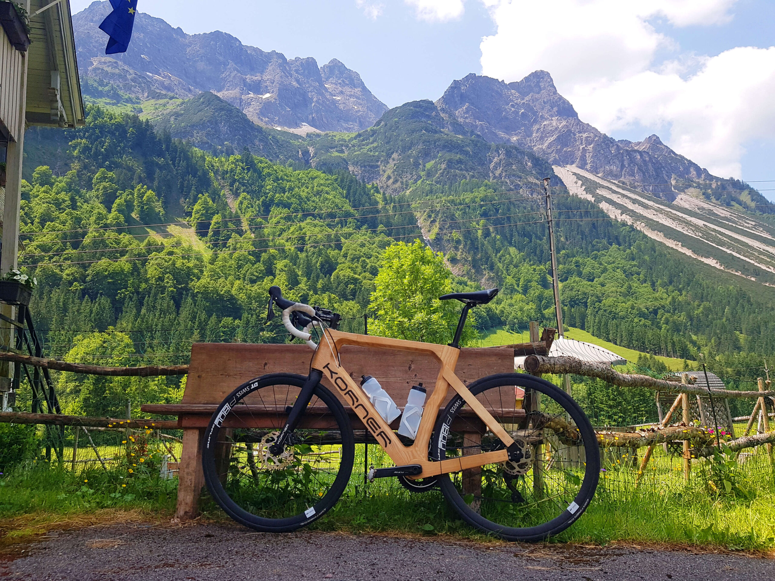 Korner Shiqane leaning to a bench with the sunny alps in the background